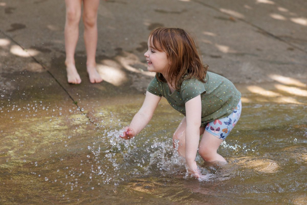 Guests play in the stream on the Aquarium plaza.