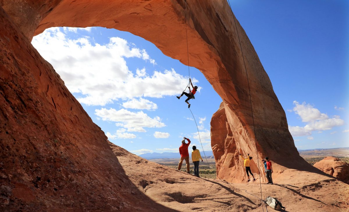 Climber Miranda Oakley dangles delicately under Wilson’s Arch in Moab, Utah.