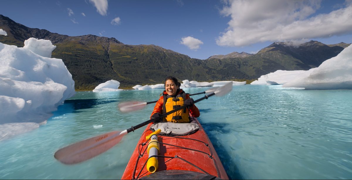 Ariel Tweto paddles a tandem kayak through the arctic blue waters of Spencer Glacier in Chugach National Forest, Alaska.