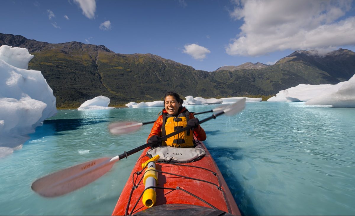 Ariel Tweto paddles a tandem kayak through the arctic blue waters of Spencer Glacier in Chugach National Forest, Alaska.