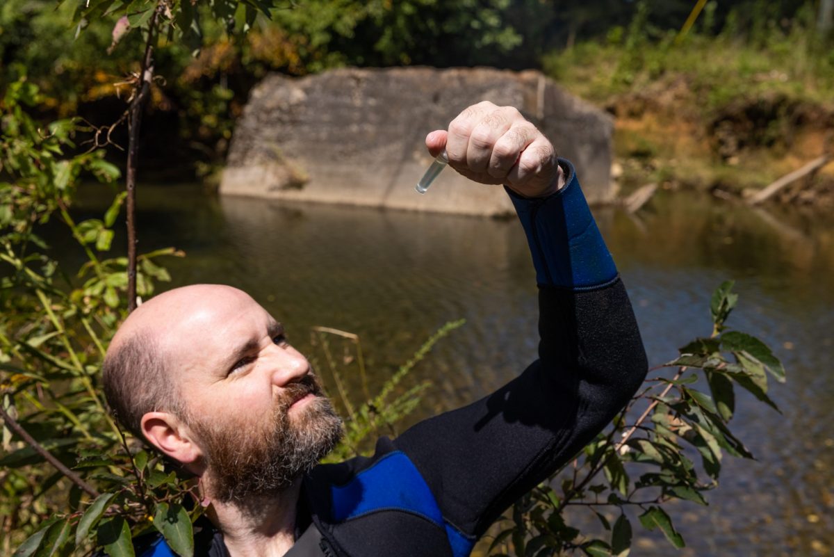 Senior Aquarist Ben Stenger checks to ensure a fin clip from a Bridled Darter is properly stored in a container