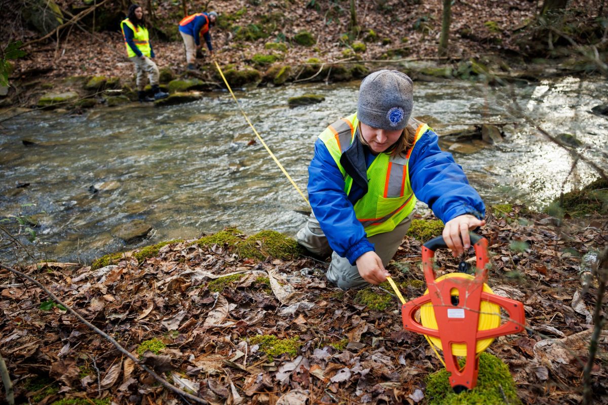 Recovery Biologist Shawna Fix measures the width of a stream while working on a conservation project to identify and replace culverts that restrict the passage of fish.