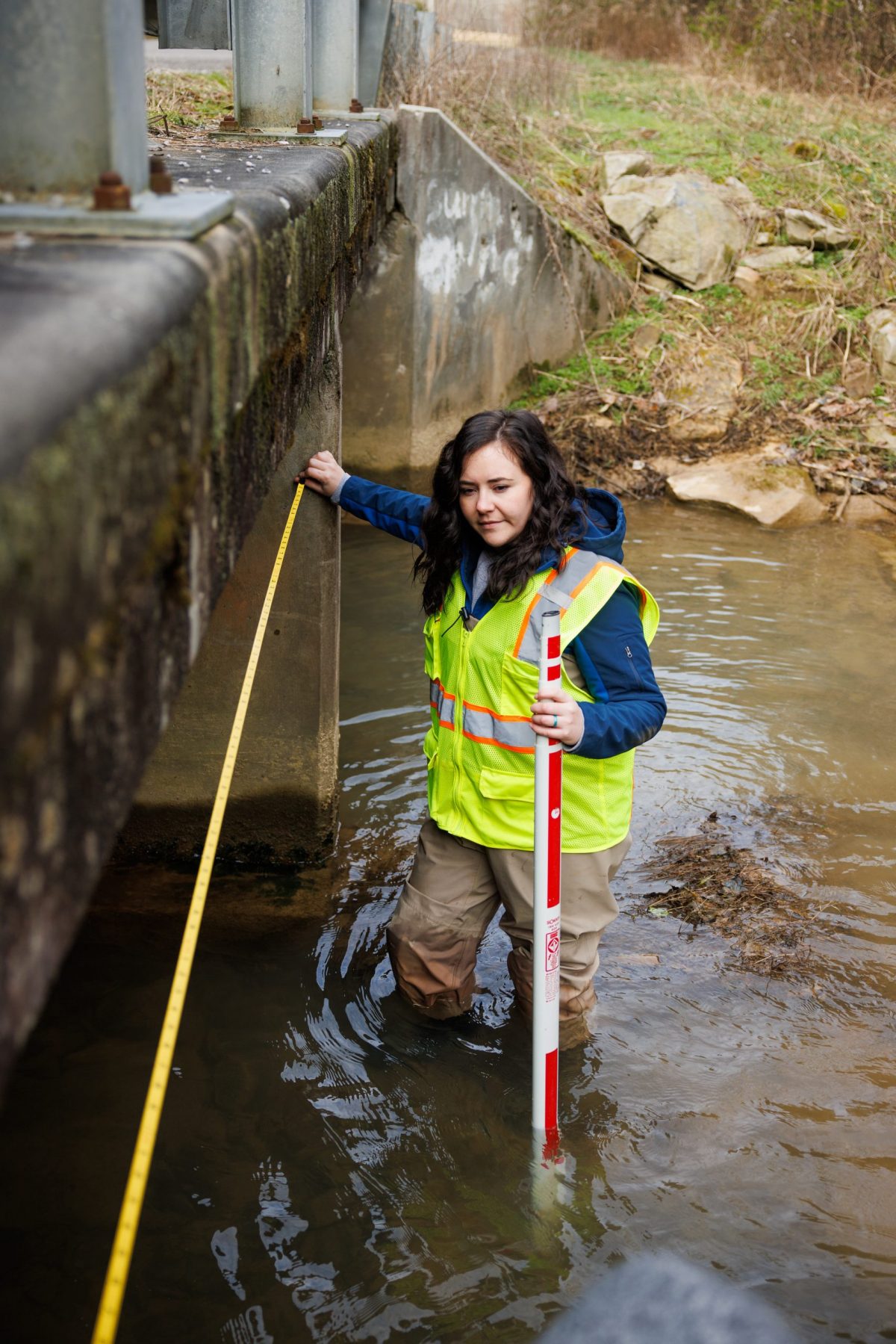 Reintroduction Biologist Sarah Kate Bailey measures a culvert while working on a conservation project to identify and replace culverts that restrict the passage of fish.