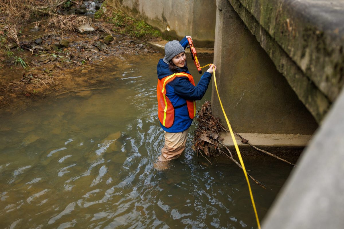 Reintroduction Assistant Teresa Israel measures a culvert while working on a conservation project to identify and replace culverts that restrict the passage of fish.