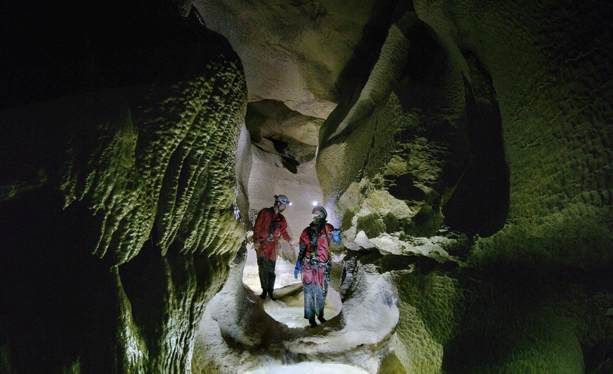 Deep inside Grotte de Gournier, Dr. Gina Moseley and Chris Blakeley navigate down a riverbed with deep pools.
