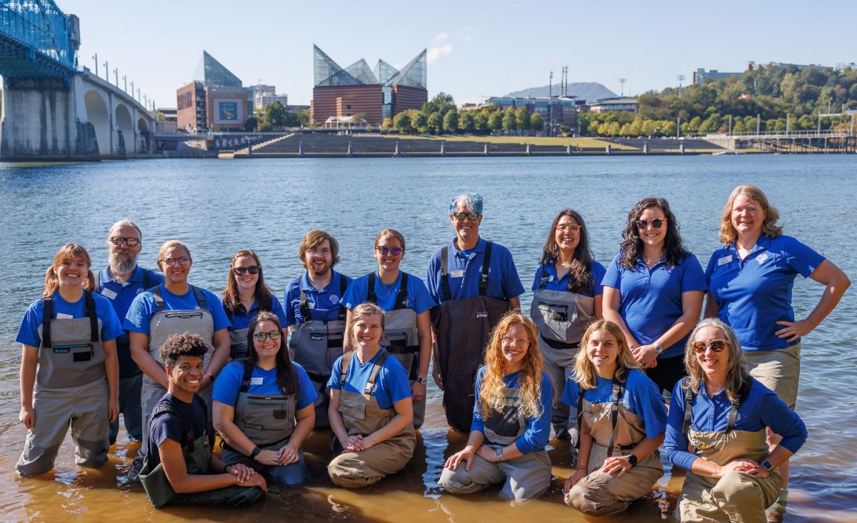 Conservation scientists with the Tennessee Aquarium Conservation Institute pose in the Tennessee River before releasing more than 600 juvenile Lake Sturgeon into the waterway.