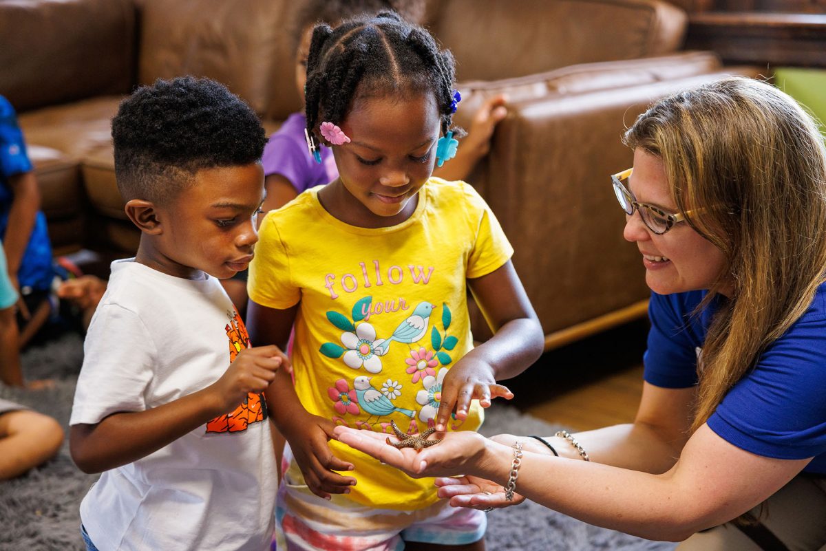 Community Engagement Educator Claudia Mendez-marti shows a sea star to children during an education outreach program at Chambliss Center for Children.