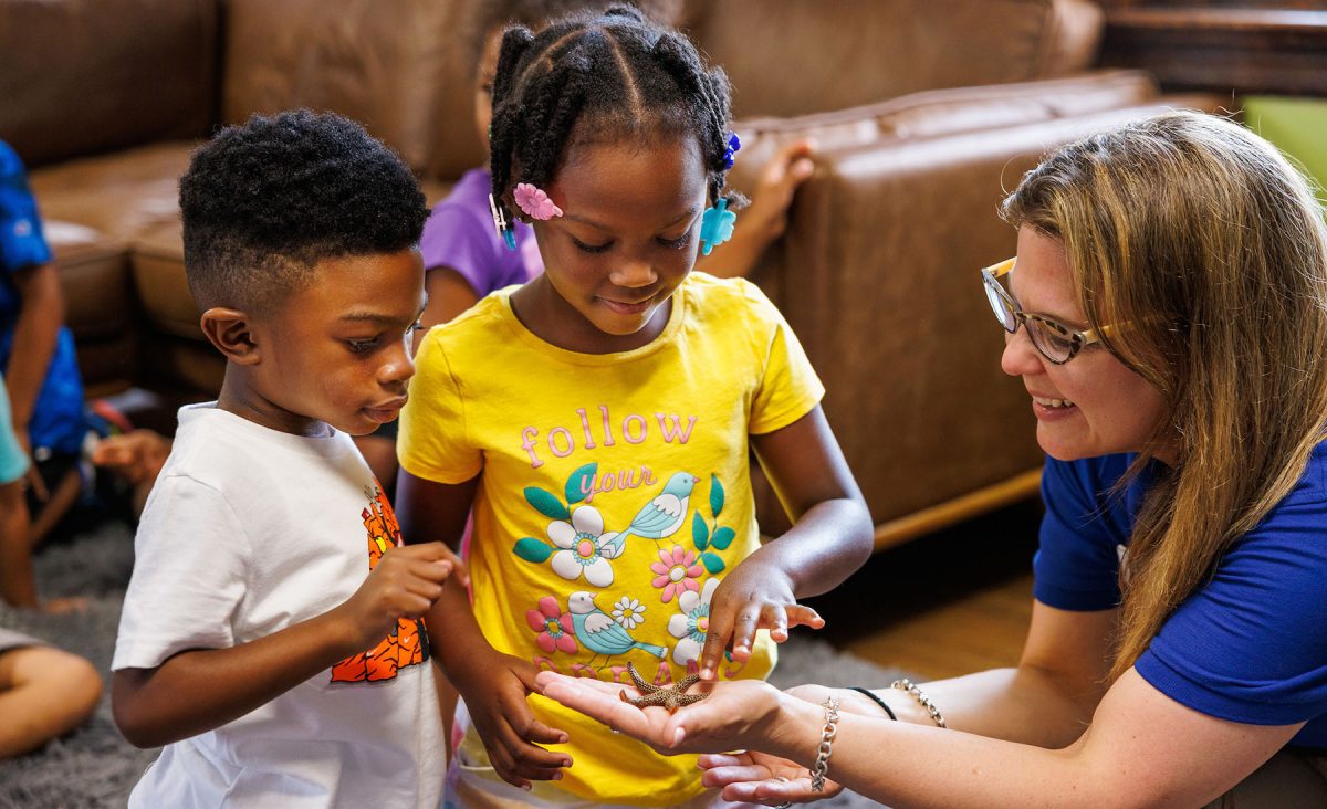 Community Engagement Educator Claudia Mendez-marti shows a sea star to children during an education outreach program at Chambliss Center for Children.