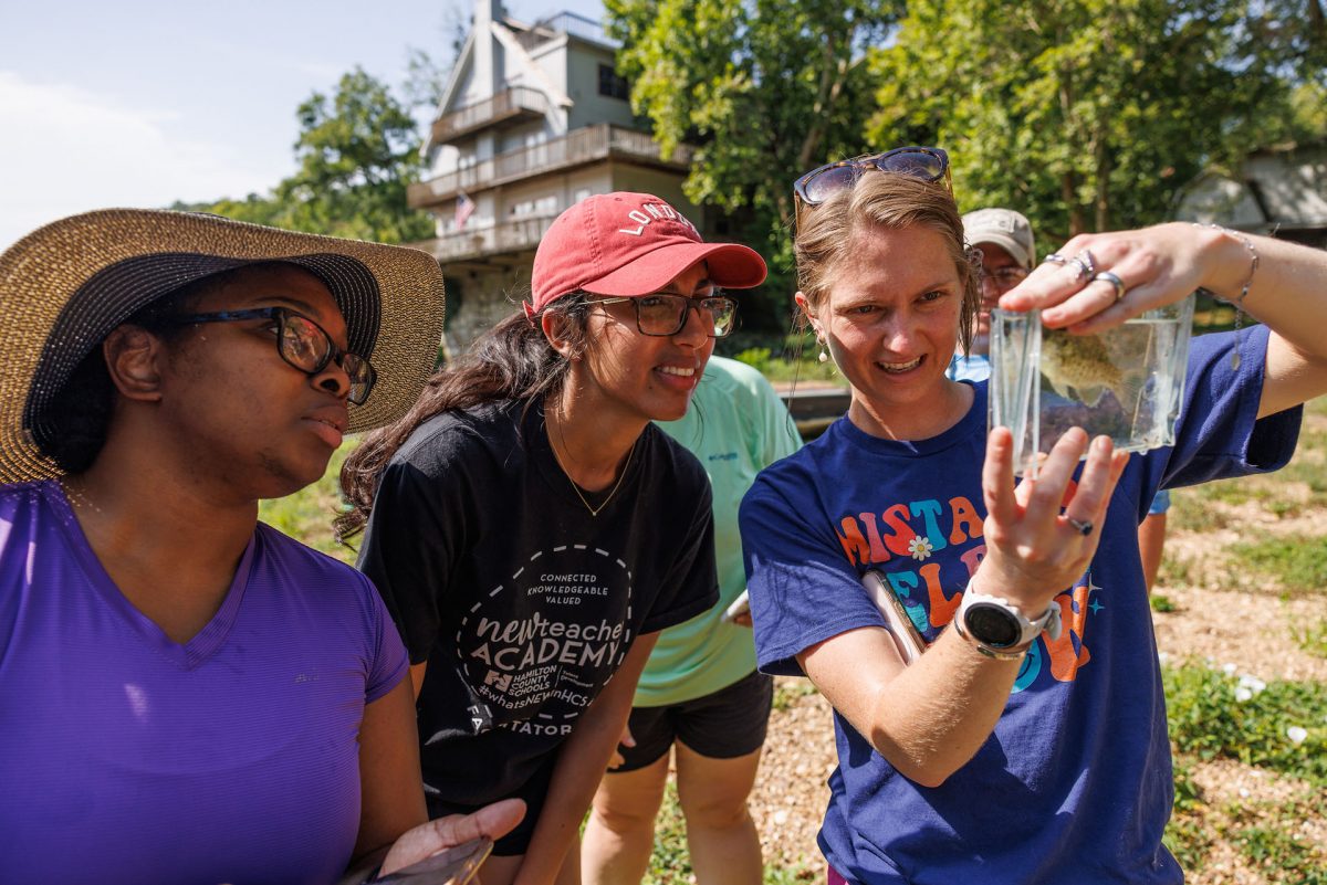 teachers look at a fish in a viewing aquarium