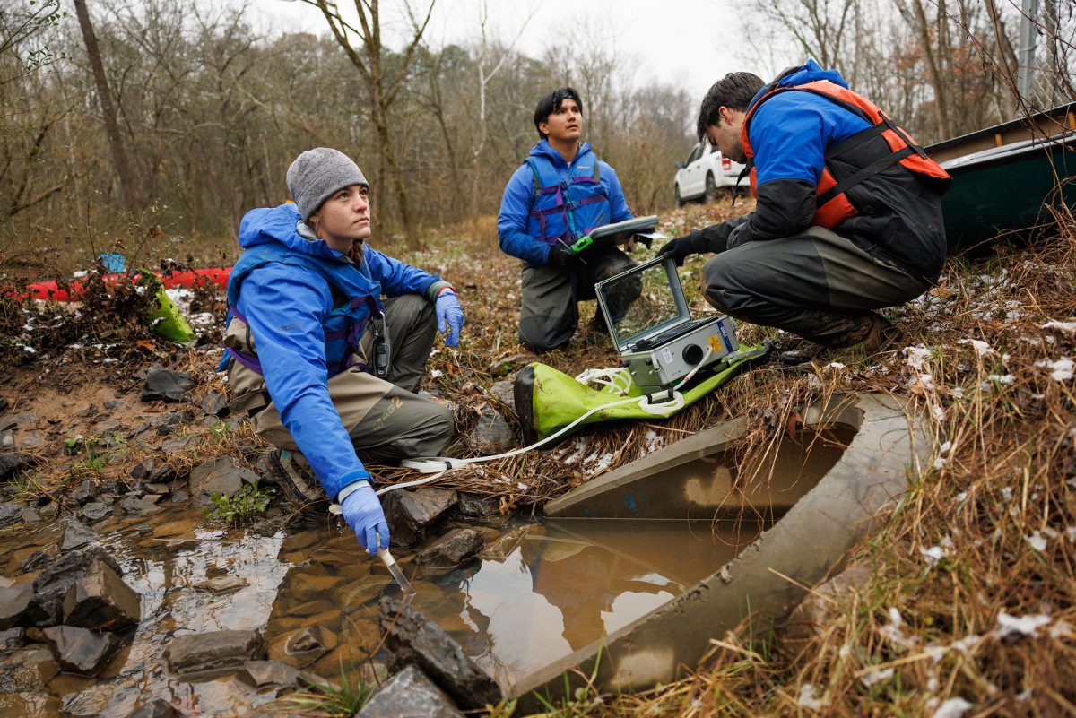 Scientists using a machine to sample water in a stream