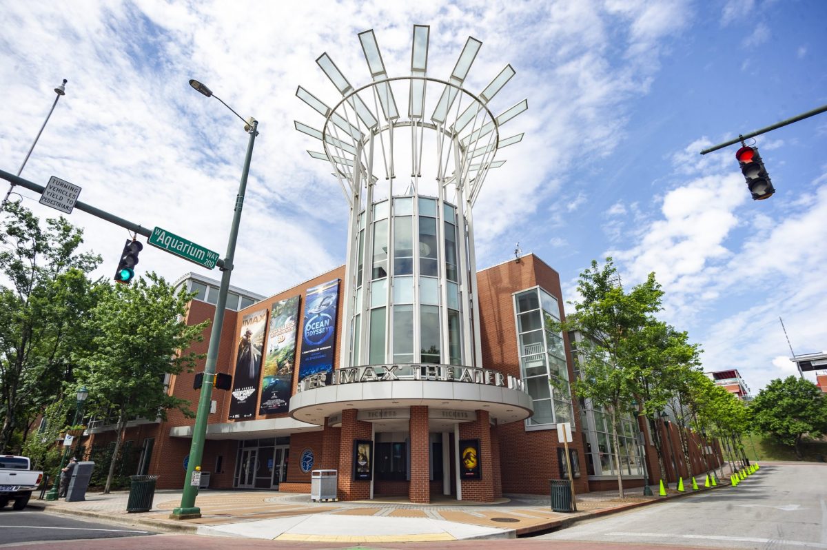 A street level view of the exterior of the Tennessee Aquarium IMAX 3D Theater, looking up toward a partly cloudy sky