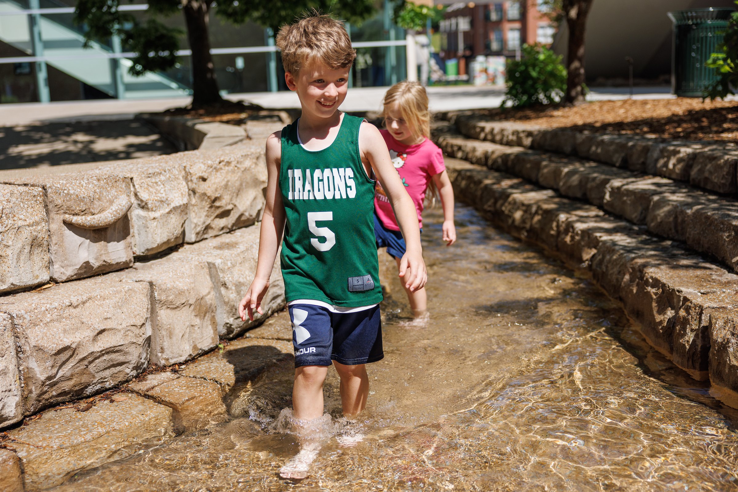 Guests play in the stream on the Aquarium plaza.