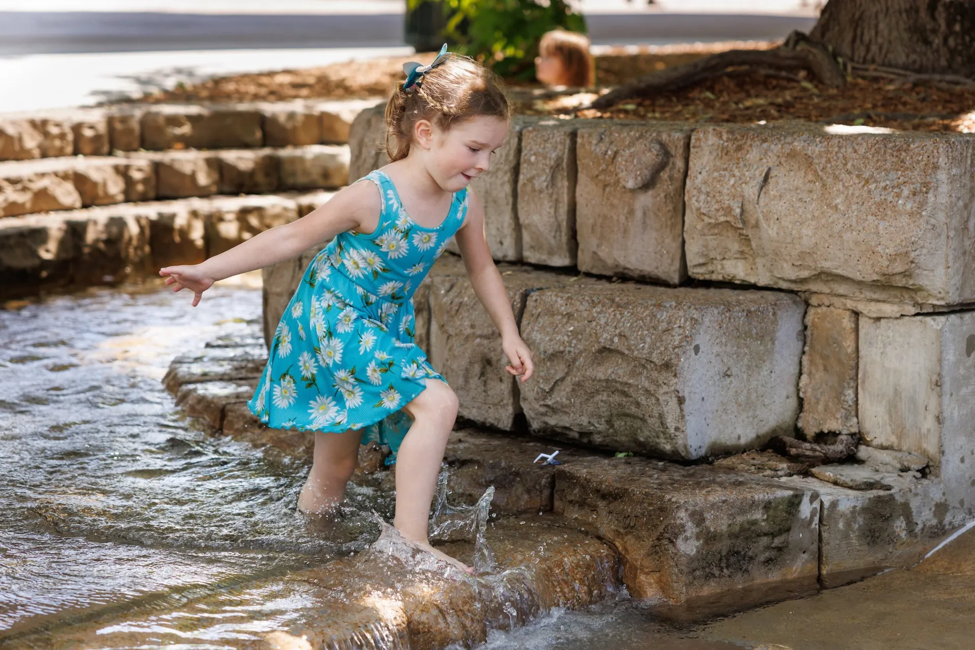 Girl playing in plaza fountain