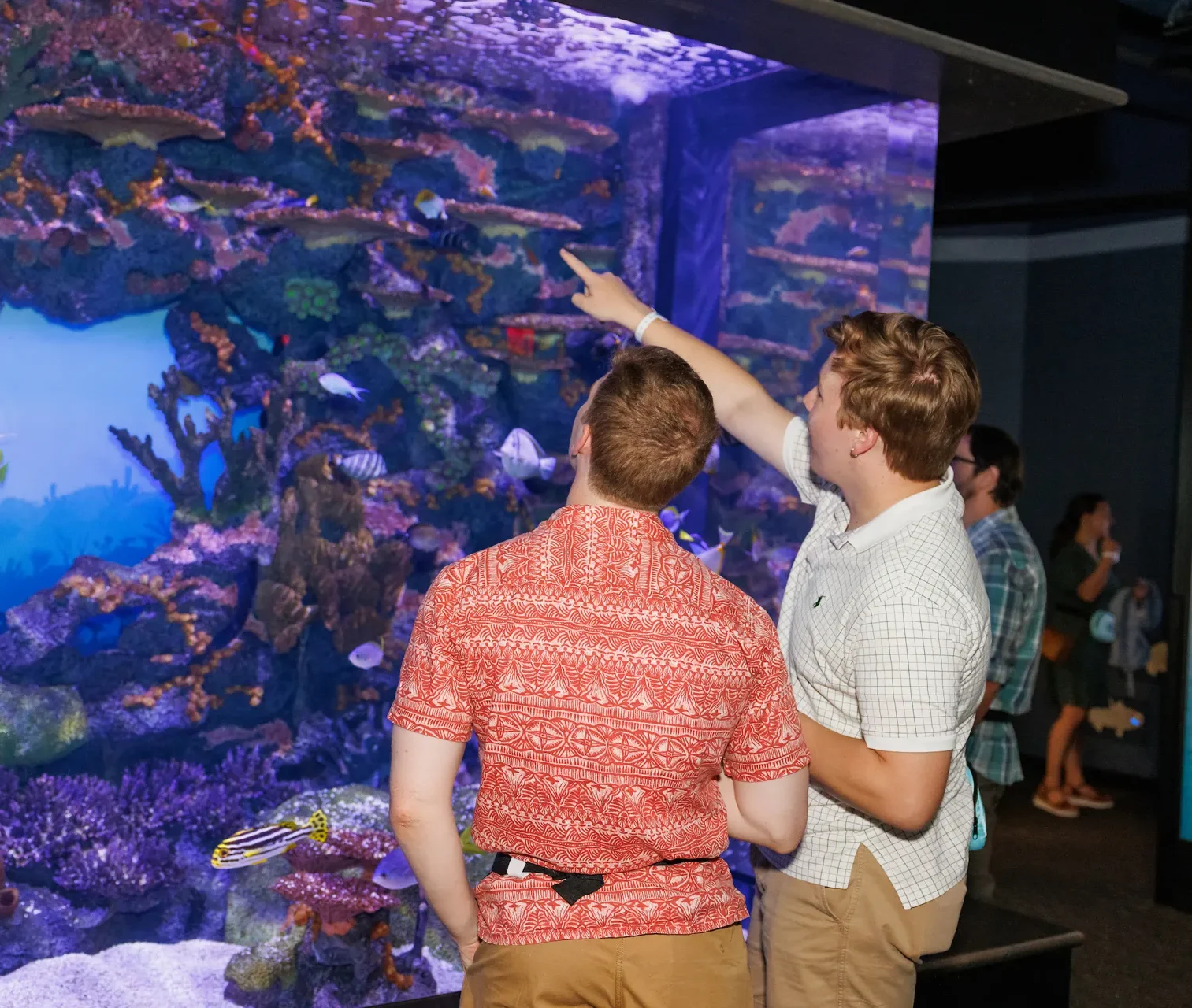 Two guests in front of the Tropical Fish tank in Ocean Journey