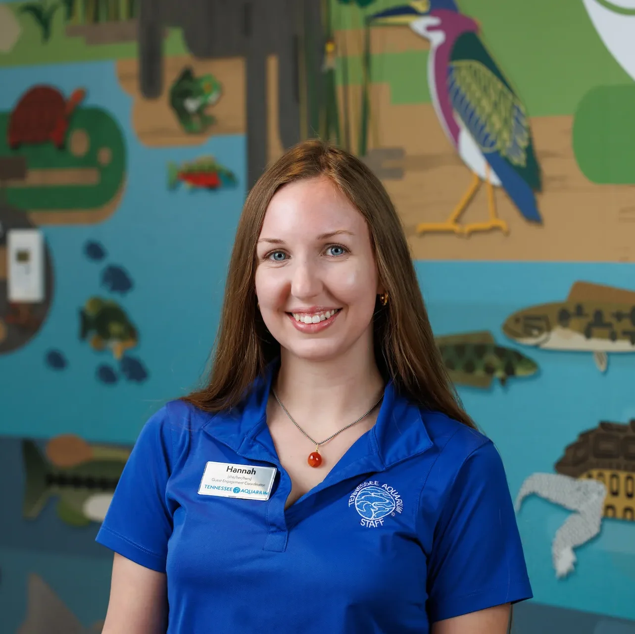 Headshot of TN Aquarium Guest Engagement Coordinator Hannah Shepperd with a mural in the background