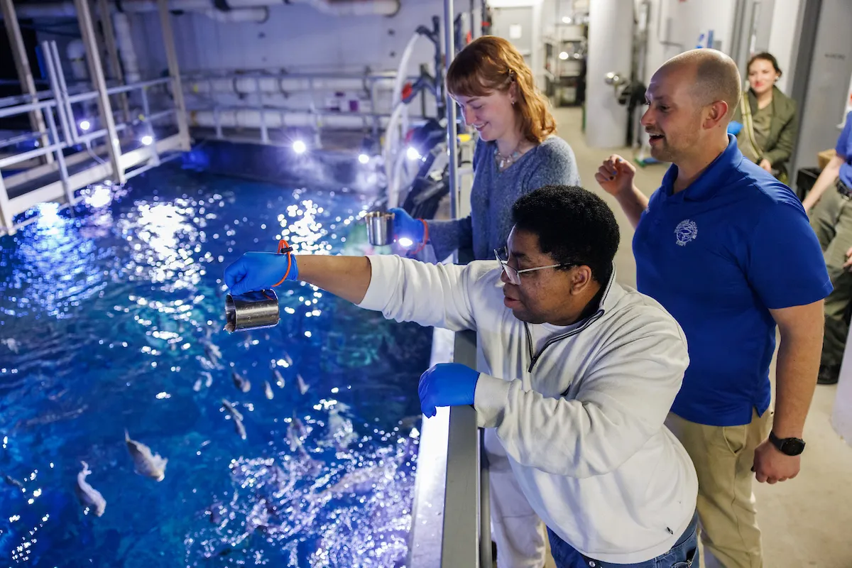 Two guests participating in the Deeper Dives: Feeding Frenzy behind the scenes tour