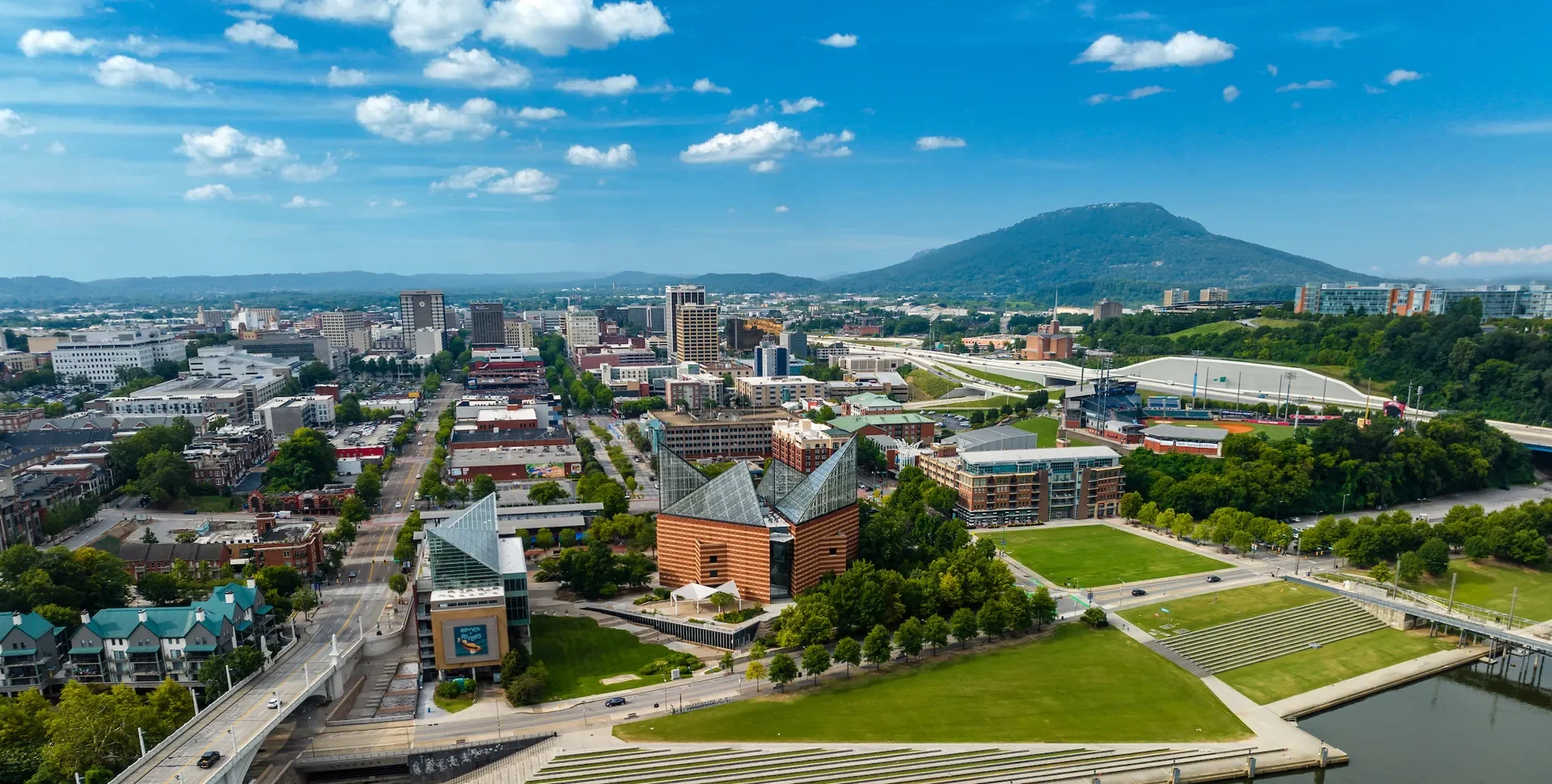 Sunny day aerial exterior photo of the Tennessee Aquarium and downtown Chattanooga in the distance