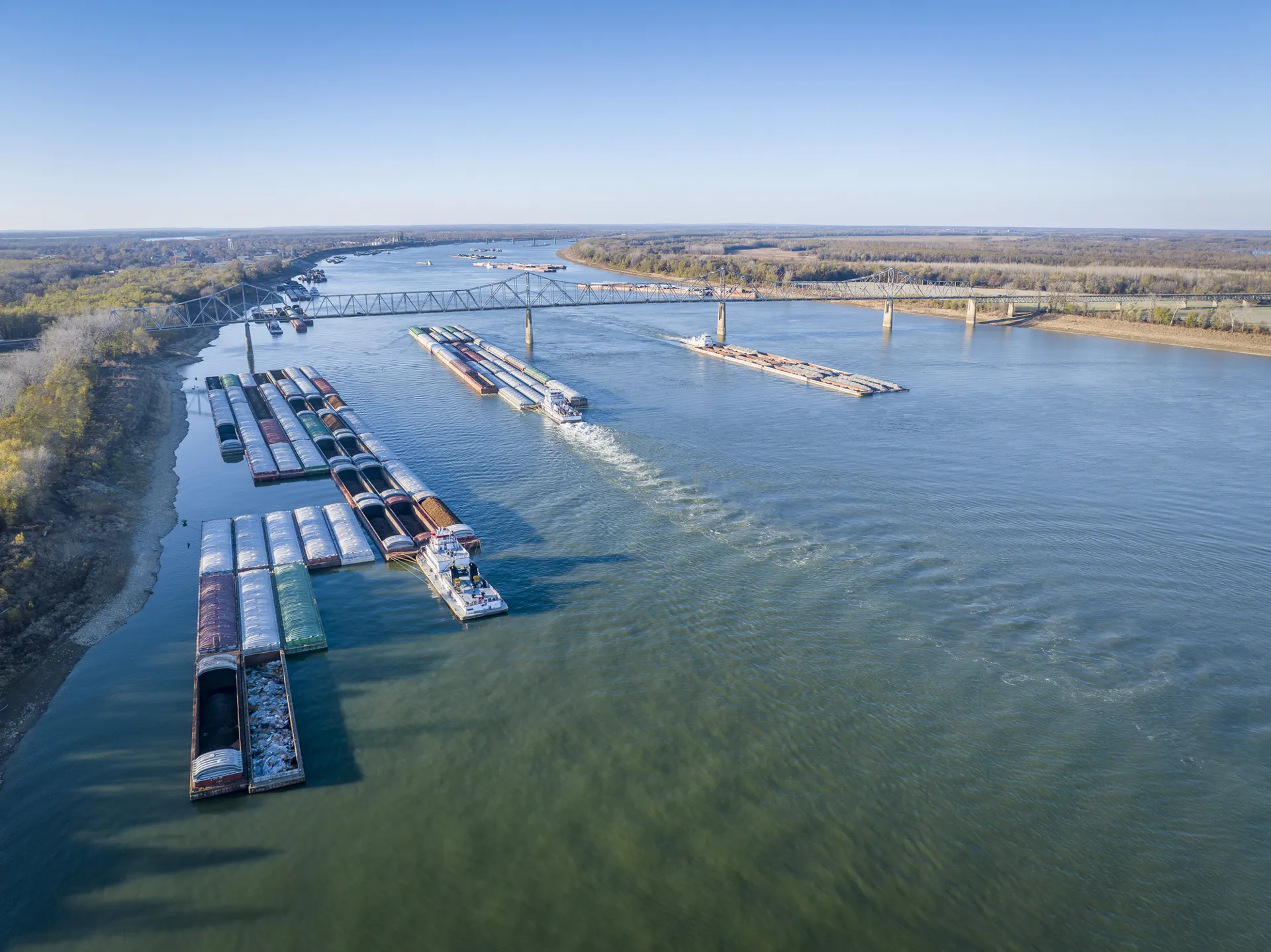 An aerial view of the Ohio River. Towboats and barges crowd the water near the river's confluence with the Mississippi RIver at Cairo, Illinois.