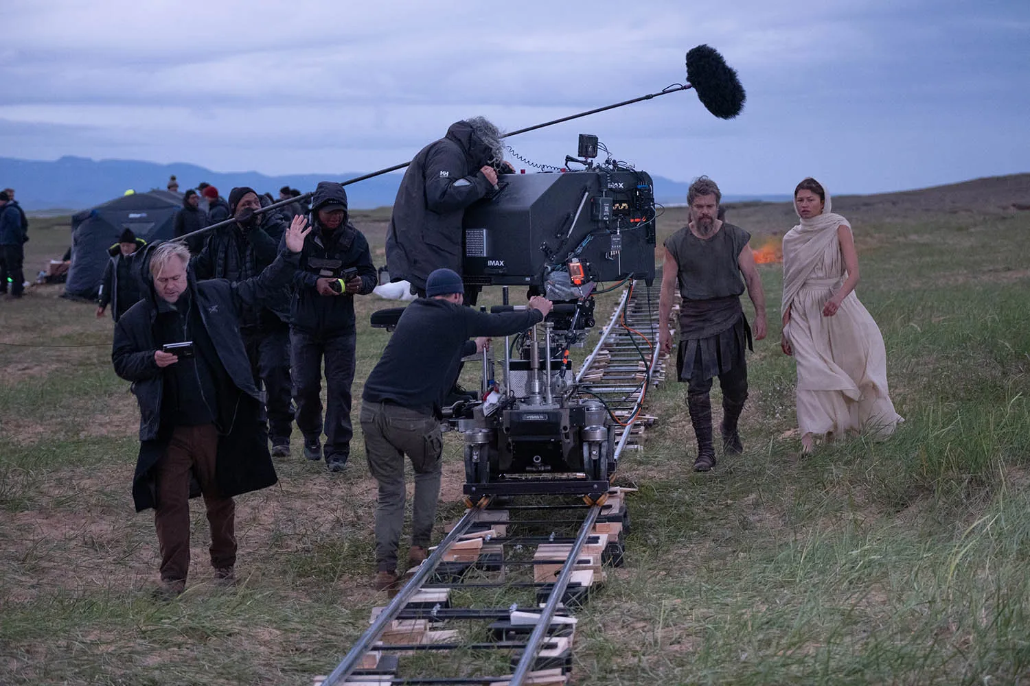 Director Christopher Nolan (frame left) with Matt Damon (as Odysseus) and Zendaya (as Athena), on set of his film The Odyssey, written, produced, and directed by Christopher Nolan (Credit: Melinda Sue Gordon/Universal Pictures).